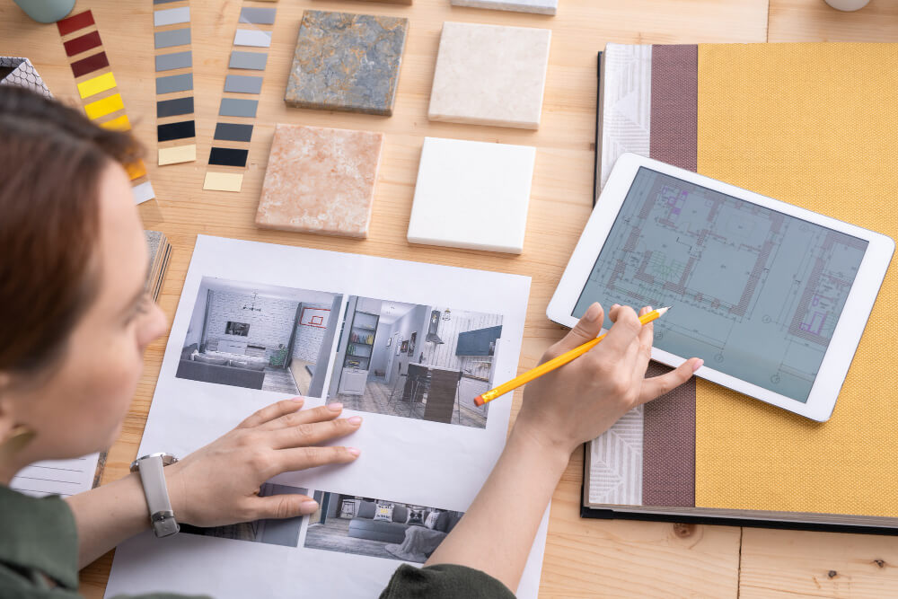 creative female designer interior looking through apartment plan digital tablet choosing example photo by workplace