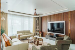 Modern luxury living room interior with sofa set, TV wall, glass coffee table, and large windows